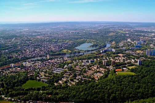 Luftaufnahme des Stadtbezirks Stuttgart-Mühlhausen bei strahlend blauem Himmel mit dem Max-Eyth-See, dem Neckar, Wiesen, Wäldern und Wohnsiedlungen.